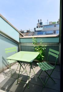 - Balcón con mesa verde y 2 sillas en High End Attic Flat in the City Centre en Viena