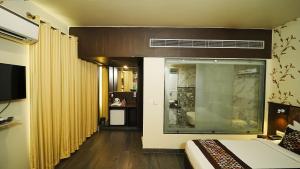 Habitación de hotel con cama y ventana en Hotel Atulyaa Taj, en Agra