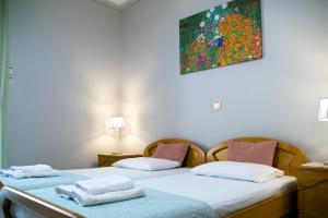 two beds in a room with a painting on the wall at Paradise residency in Iraklitsa