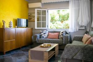 ein Wohnzimmer mit einem Sofa und einem Tisch in der Unterkunft Paradise residency in Nea Iraklitsa