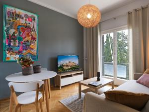 a living room with a table and a tv at BeautIful apartment in Kolonaki in Athens