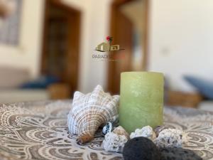 a candle and seashells sitting on a table at Villa Bonita in Corralejo