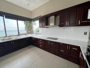 a kitchen with wooden cabinets and a view of the ocean at Nancy Tran Grand Strip Vung Tau Villa 10 in Vung Tau