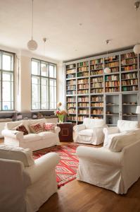 ein großes Wohnzimmer mit weißen Sofas und Bücherregalen in der Unterkunft Transylvania Guesthouses in Cincşor
