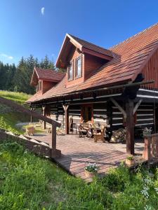 a log cabin with a wooden deck in front of it at Chata Wetłyna II in Wetlina