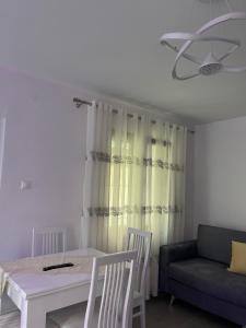 een woonkamer met een tafel en een bank bij Ilia’s Guesthouse in Pogradec