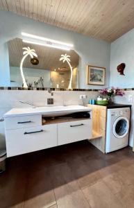 a bathroom with a sink and a washing machine at Haus Sonnenau in Pfronten