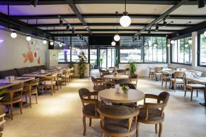 a restaurant with tables and chairs and windows at Resun Hotel in Ankara
