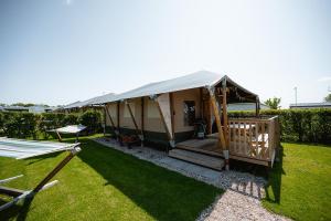 een yurt met een veranda in een tuin bij Glamping Kamperland in Kamperland