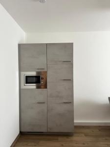 a kitchen with a stainless steel cabinet with a microwave at Sehr schöne Wohnung,komplett neu eingerichtet in Limbach-Oberfrohna