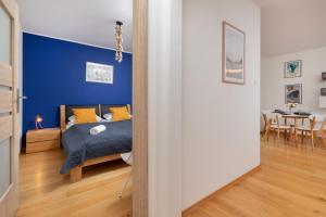 1 dormitorio con 1 cama con pared azul en Modern Gdynia Apartment with Balcony & Parking by Renters, en Gdynia