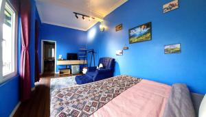 Dormitorio azul con cama y pared azul en Catcat Garden House, en Sa Pa