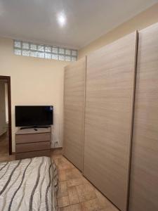 Schlafzimmer mit einem Bett und einem Flachbild-TV in der Unterkunft Jambo House in Velletri