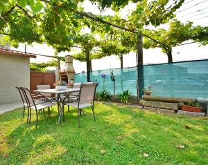 una mesa y sillas en un patio con vistas al agua en Casa con jardín en Pontevedra en Pontevedra