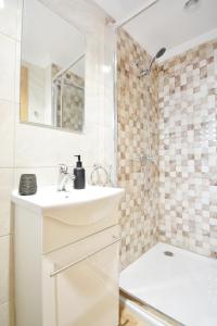 a white bathroom with a sink and a shower at Casa con jardín en Pontevedra in Pontevedra