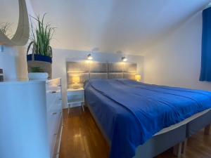 a bedroom with a bed with a blue blanket on it at Apartments Time Off in Zaboric