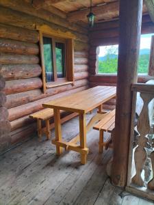 een houten tafel en banken in een blokhut bij "Бджілка" і " Садиба для відпочинку" in Lyuta