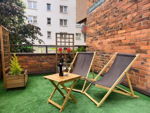 twee stoelen en een tafel op een patio bij Punkt Nieruchomości in Katowice