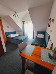 a room with two beds and a table in it at Willa Kwiatano - Plac zabaw & Jacuzzi & Basen & Sauna - Budynek C in Grzybowo +33 photos
