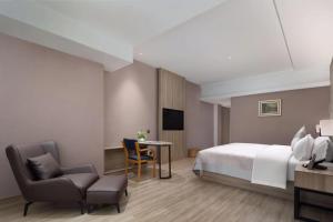 Un dormitorio con una cama y una mesa y sillas. en Morninginn, Lengshuijiang Yanjiang Road, en Lengshuijiang
