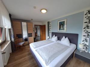 a bedroom with a large white bed in a room at Ferienwohnungen Blum in Kelberg