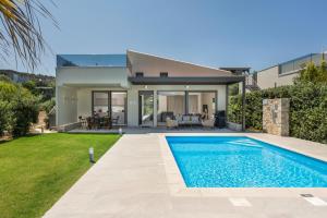 a villa with a swimming pool in front of a house at Ethereal Villas Chania in Daratso
