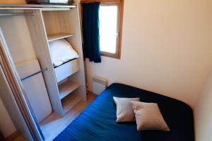 a small room with a bed and a window at Chalet mitoyen tout confort in Cauterets