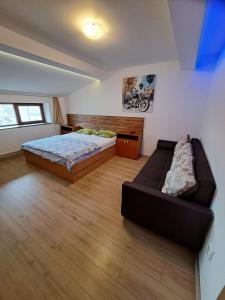 - une chambre avec un lit et un canapé dans l'établissement Apartment Cozia, à Timişoara