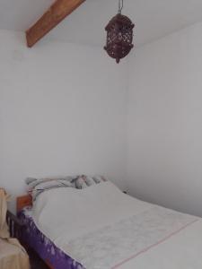 a bed in a white room with a chandelier at Gradina 5 elemente in Eforie Nord