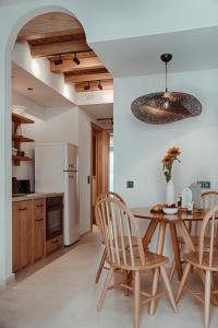 eine Küche mit einem Tisch und Stühlen sowie einem Kühlschrank in der Unterkunft Om Living Afitos in Afytos