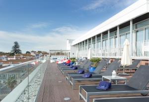 a row of lounge chairs on the roof of a building at Hotel Baia in Cascais