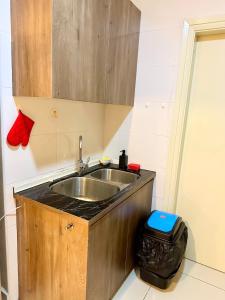 uma cozinha com um lavatório e uma lata de lixo em Comfy+ by ARH KLCC em Kuala Lumpur