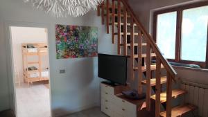 uma sala de estar com uma escada e uma televisão em Villa Gioia Civita em Fabriano