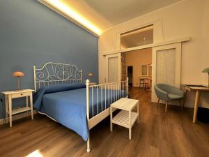 1 dormitorio con 1 cama azul y 1 silla en B&B La Farfalla, en Pescara