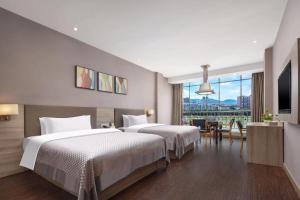 Una habitación de hotel con dos camas y una gran ventana. en Morninginn, Lengshuijiang Yanjiang Road, en Lengshuijiang