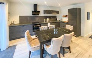a kitchen with a black table and white chairs at Amazing Home In Bjryhamn With Wifi And 4 Bedrooms 