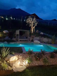 a swimming pool in a yard at night at Apfel Chalet Feldhof in Caines