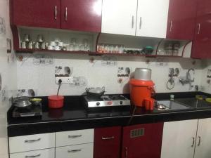 a kitchen with red cabinets and a mixer on the counter at POP Ain Ul Noor Homestay in Thanna Mandi