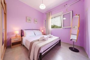 a purple bedroom with a bed and a window at Irene's Olive Guest house in Sami