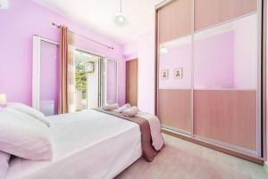 a pink bedroom with a large bed and a glass door at Irene's Olive Guest house in Sami