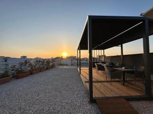 a rooftop deck with tables and chairs on a building at Casa Ntore Luxury Apartments in Chania Town