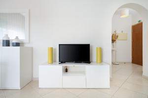 a living room with a tv on a white cabinet at IsaBela Holidays in Olhos de Água