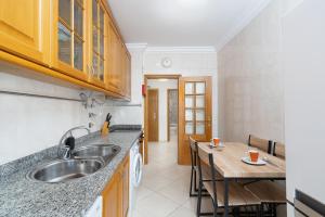 a kitchen with a sink and a wooden table at IsaBela Holidays in Olhos de Água