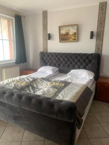 a large bed with a leather headboard in a bedroom at Apartament Hexagon 33 - 5D Apartamenty in Grzybowo