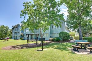 a park with picnic tables and a house at Myrtle Beach Resort Condo - Walk to Beach! in Myrtle Beach