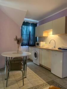 a kitchen with a table and a sink and a washing machine at Apartament Hexagon 33 - 5D Apartamenty in Grzybowo