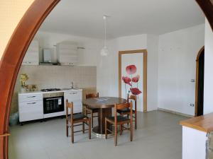 a kitchen and dining room with a table and chairs at Next stop Paestum in Paestum