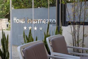 a group of chairs in front of a hotel entrance at Boutique Hotel Intermezzo - Pag centre in Pag