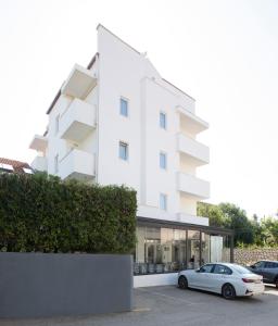 um carro branco estacionado em frente a um edifício em Boutique Hotel Intermezzo - Pag centre em Pag