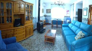 a living room with a blue couch and a tv at Casa rural la casa del Conde in Puebla de la Parrilla